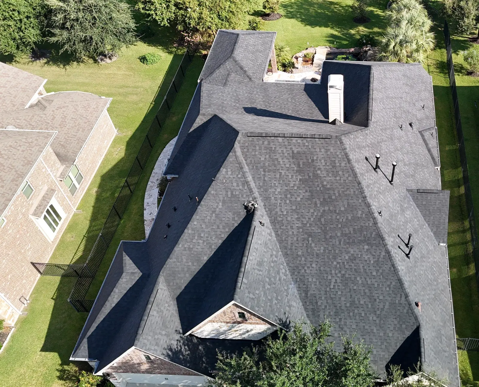 Aerial view of a large dark shingle roof with multiple valleys