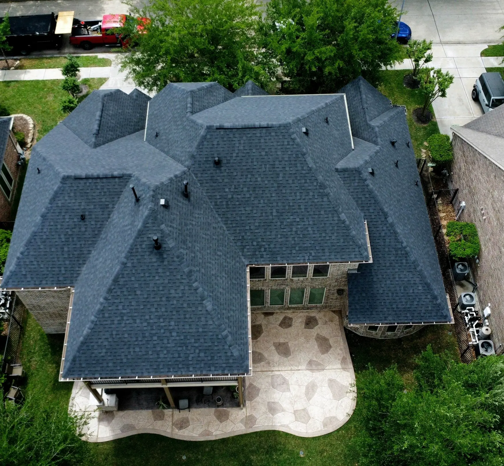 Overhead view of a complex hip roof finished in new dark shingles